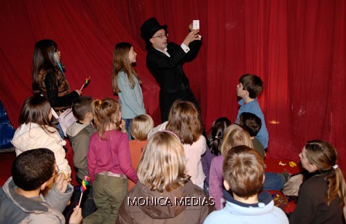Le magicien fait des tours de cartes face aux enfants eblouis