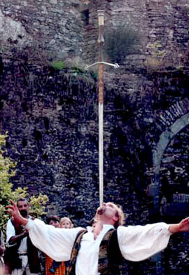 L'artiste acrobate maintient une epee sur son menton a la verticale sur la pointe de la lame pour un show a l'exterieur 