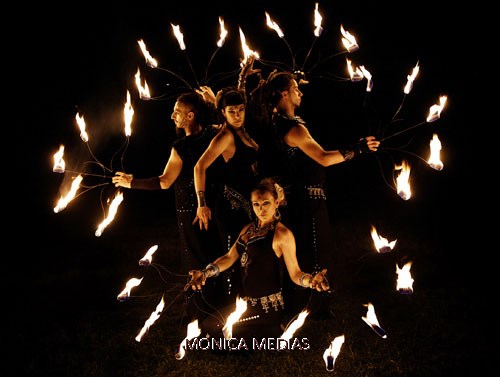 Quatre jongleurs au milieu des flammes forment un cercle