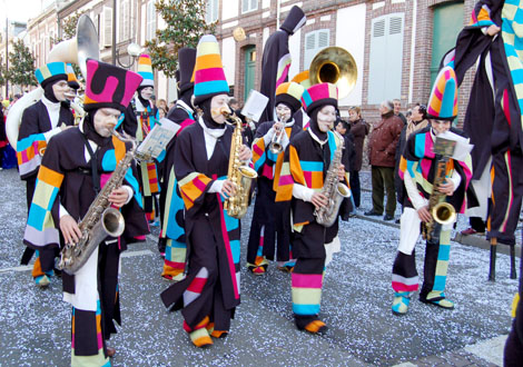 Les musiciens accompagnent au sol les echassiers rigolos en portant les memes costumes colores