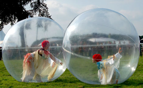 Deux danseuses contorsionistes realisent des figures dans les bulles pour un spectacle dans la nature