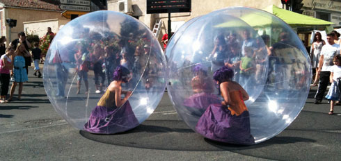 Les trois danseuses sont accroupies dans leur bulles pour un spectacle en centre ville