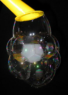 Une bulle de savon enfumee est entouree d'autres bulles de savon transparentes
