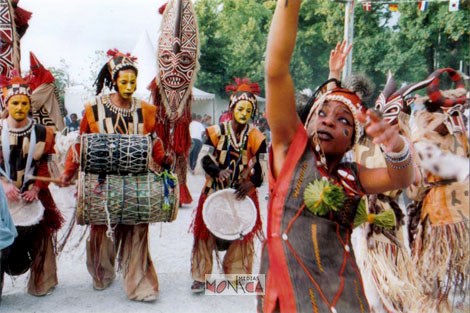 Des danseurs et musiciens costumes defilent dans la rue sur la thematique africaine