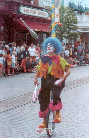 Cet artiste avec sa chevelure bleue et son costume dore jongle avec des massues tout en se tenant sur son monocycle