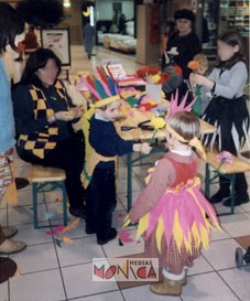 Une animatrice costumiere deguise  les enfants autour de son atelier en petites reines et rois