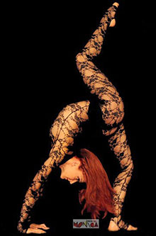 Une artiste contorsionniste realise un numero de grand ecart et equilibre le dos cambre vers l arriere
