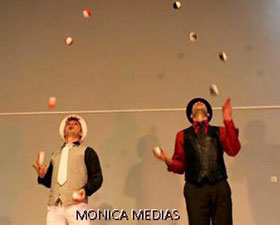 Duo de jongleurs costumes s'echangeant des balles sur scene