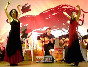 Danseuses espagnoles en robes rouges et noires et guitariste de flamenco aux influences gitanes et argentines