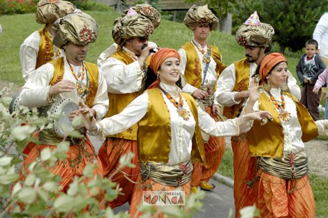 Le groupe de musique orientale deambule en dansant dans un parc de la ville