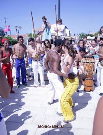 Un homme et une femme capoeiristes dansent corps à corps sur de la musique bresilienne lors d'un spectacle de capoeira