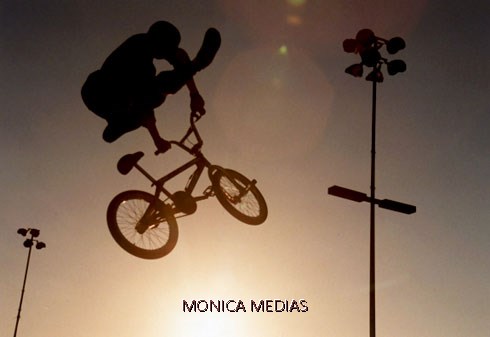 Un freestyler de BMX effectue une figure aerienne en decollant ses pieds des pedales lors d'un show nocturne