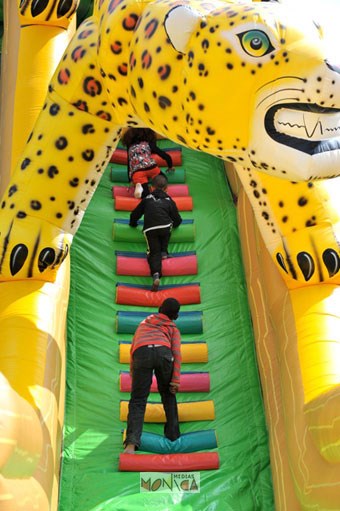 Des enfants qui montent dans un toboggan gonflable avec panthere