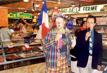 Un animateur et un clown mettent l'ambiance sur un marche couvert