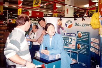 Un animateur attire des visiteurs sur le stand Bouygues pour le lancement de nouveaux forfaits de telephonie