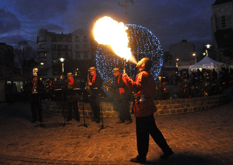 Greg illumine la place de nuit en crachant du feu