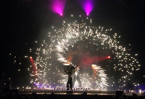 Un jongleur sur scene au mileu de gerbes de flames