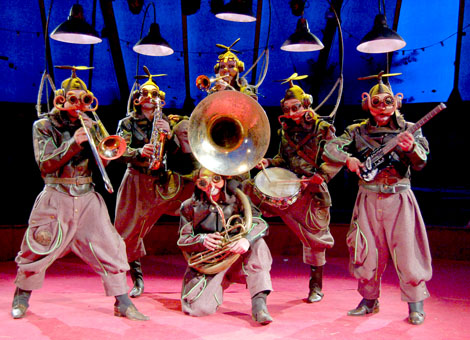 Six musiciens costumes avec de nombreux instruments differents jouent des airs de jazz manouche pour leur spectacle des fous volants
