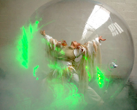 Une danseuse ouvre les bras dans une bulle pour un ballet tres feerique