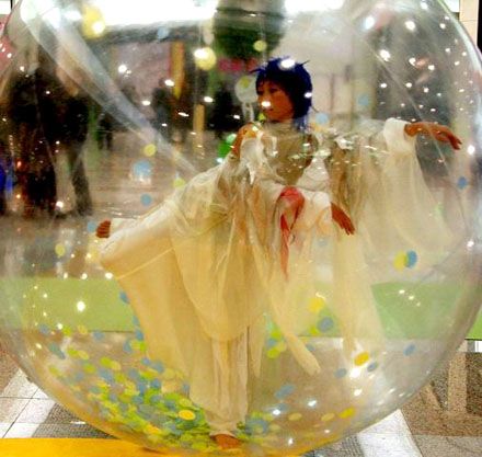 Cette danseuse en bulle se deplace dans une galerie commerciale