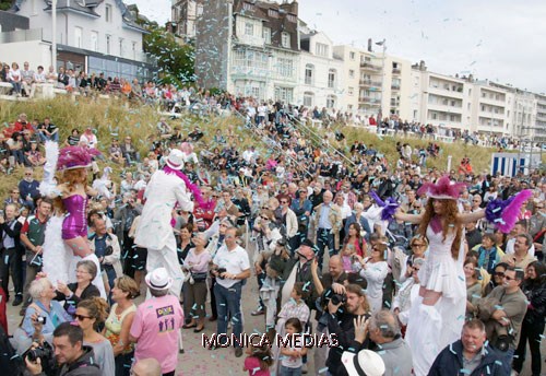 Trois echassiers cabaret belle epoque au milieu de la foule sous les cotillons