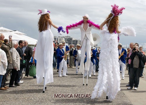 Trois echassiers cabaret belle epoque dans la rue face a la foule