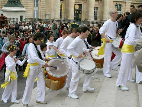 La troupe de la batucada monte les marches d'un monument pour poursuivre la fete a l'interieur