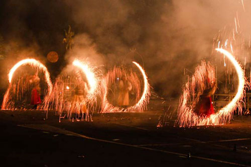 Quatre cercles de feu tournent au milieu du theatre d'artifices dans la ville de lumieres