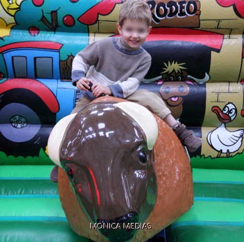 Un petit garcon se regale sur le taureau du rodeo junior
