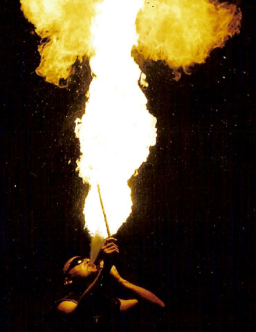 Un cracheur de feu realise une belle flambee lors de son spectacle tres brulant