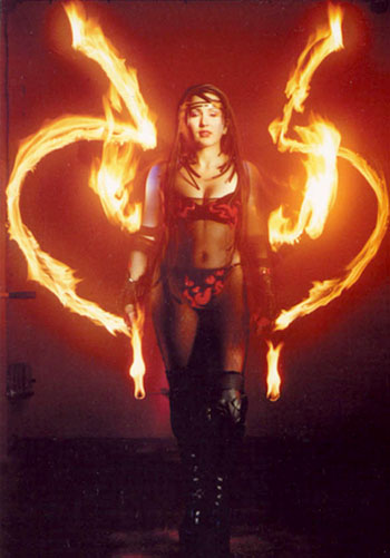Un spectacle dedie au feu se termine avec une artiste realisant des figures enflammees a l'aide de deux torches