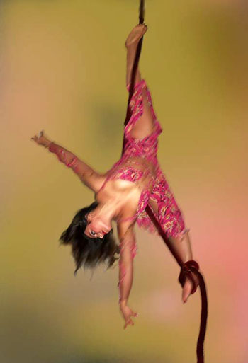 La danseuse avec un pied enroule sur la corde lisse effectue une figure dans les airs sur un fond musical 