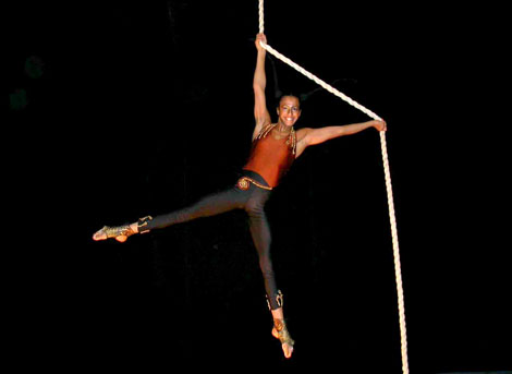 Cette danseuse fait un numero de corde lisse les bras et jambes tendus lors d'une soiree sur le theme du cirque