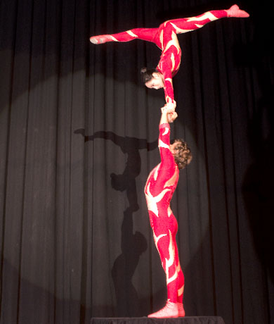 Un couple d'equilibristes sont sur scene pour un numero de main a main tres aerien