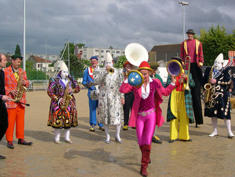 Une artiste jongle avec des chapeaux de cirque sur l'air de musique des clowns musiciens