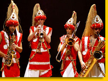 Quatre musiciens de samba aux costumes rouge et blanc font vibrer le public