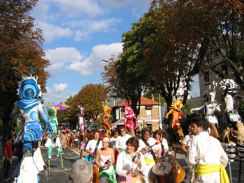 La batucada bresilienne est dans les rues au mileu d'autres artistes du defile