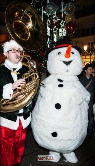 Mascotte du bonhomme de neige avec musicien du pere noel