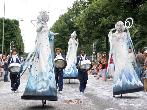 Trois reines des neiges artificieres sur echasses et trois musiciens au sol deambulent dans le coeur de la ville a Noel