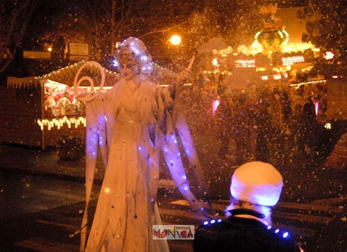 La parade des reines des neiges se poursuit jusqu'à la place eclairee de l'hotel de ville