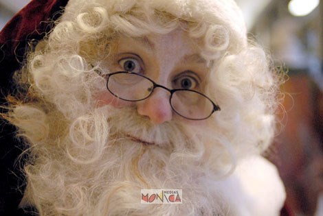 Le pere noel ouvre grand les yeux par dessus ses petites lunettes