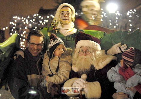 Le pere noel et ses lutins sont accompagnes d'un papa et ses tres jeunes enfants