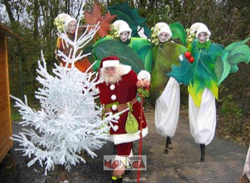 Le pere noel se cache derriere le sapin blanc suivi de ses quatre maxi lutins de noel