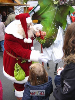 Le pere noel libere quelques flocons de neige de la manche de son manteau