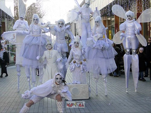 Les echassiers blancs jouets de Noel en spectacle sur un marche