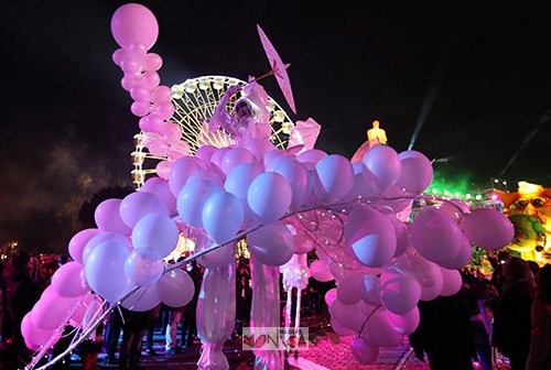 Echassiers blancs avec ballons en parade nocturne