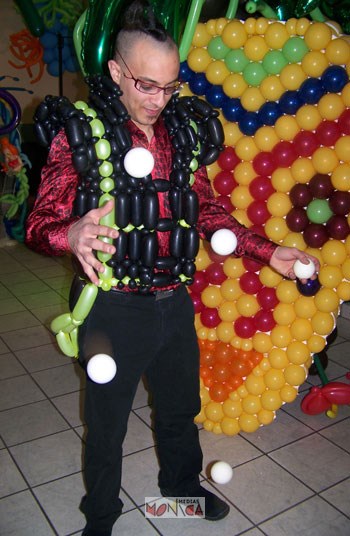 Cet artiste avec son gilet gonflable et ses lunettes d'intello jongle avec des balles.