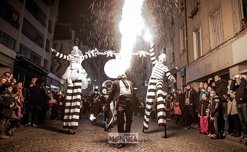 Cirque de rue deambulatoire avec echassiers cracheur de feu et musiciens