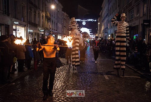 Artistes de cirque de rue nocturne avec cracheur de feu acrobate et echassiers