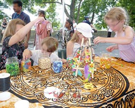 4 enfants dans un atelier d initiation artistique fabrique des compositions florales et fruitees avec des elements en bois